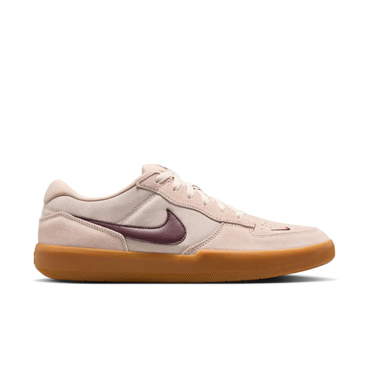 Beige sneaker with a maroon swoosh logo on a white background