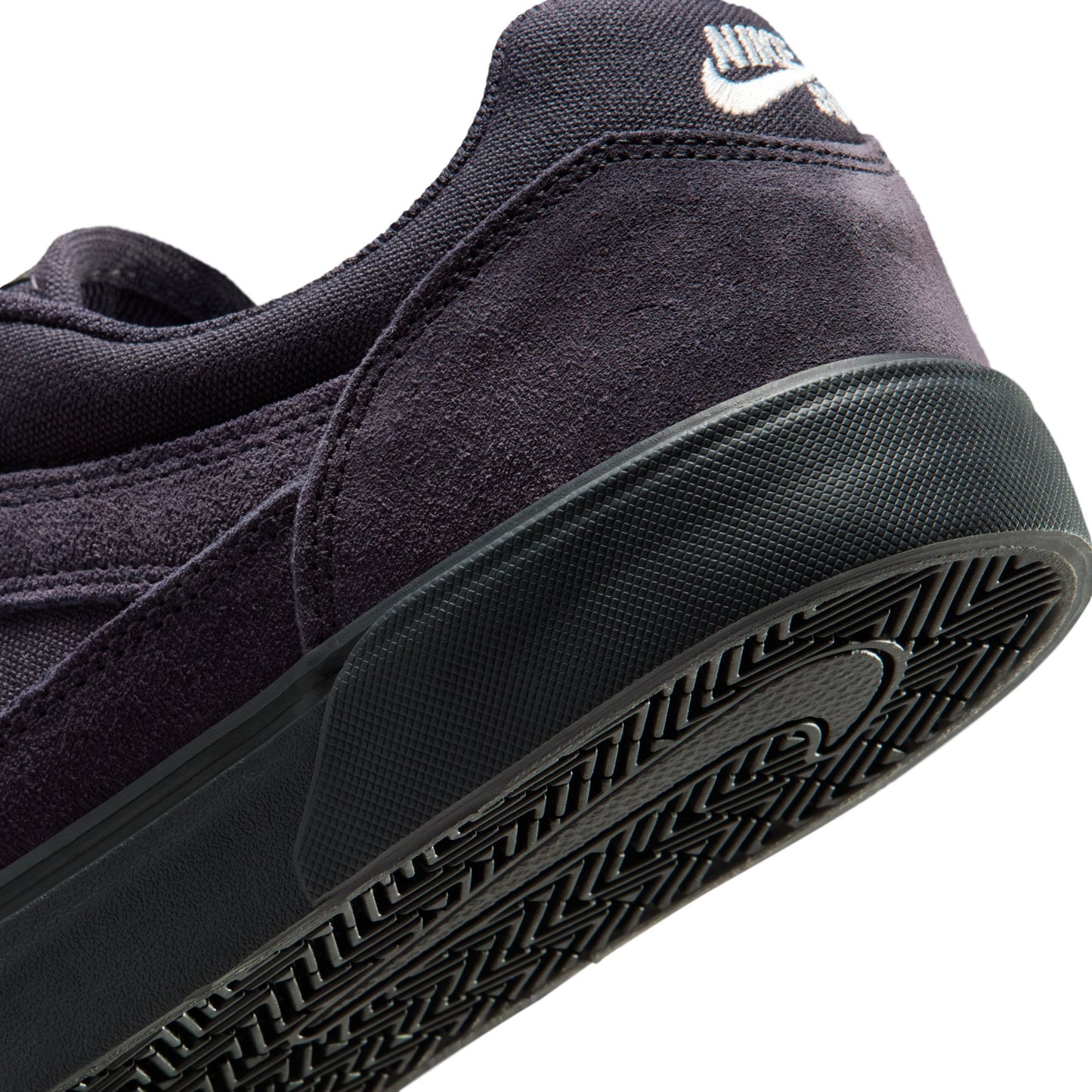 Close-up of a black sneaker with a brand logo on a white background