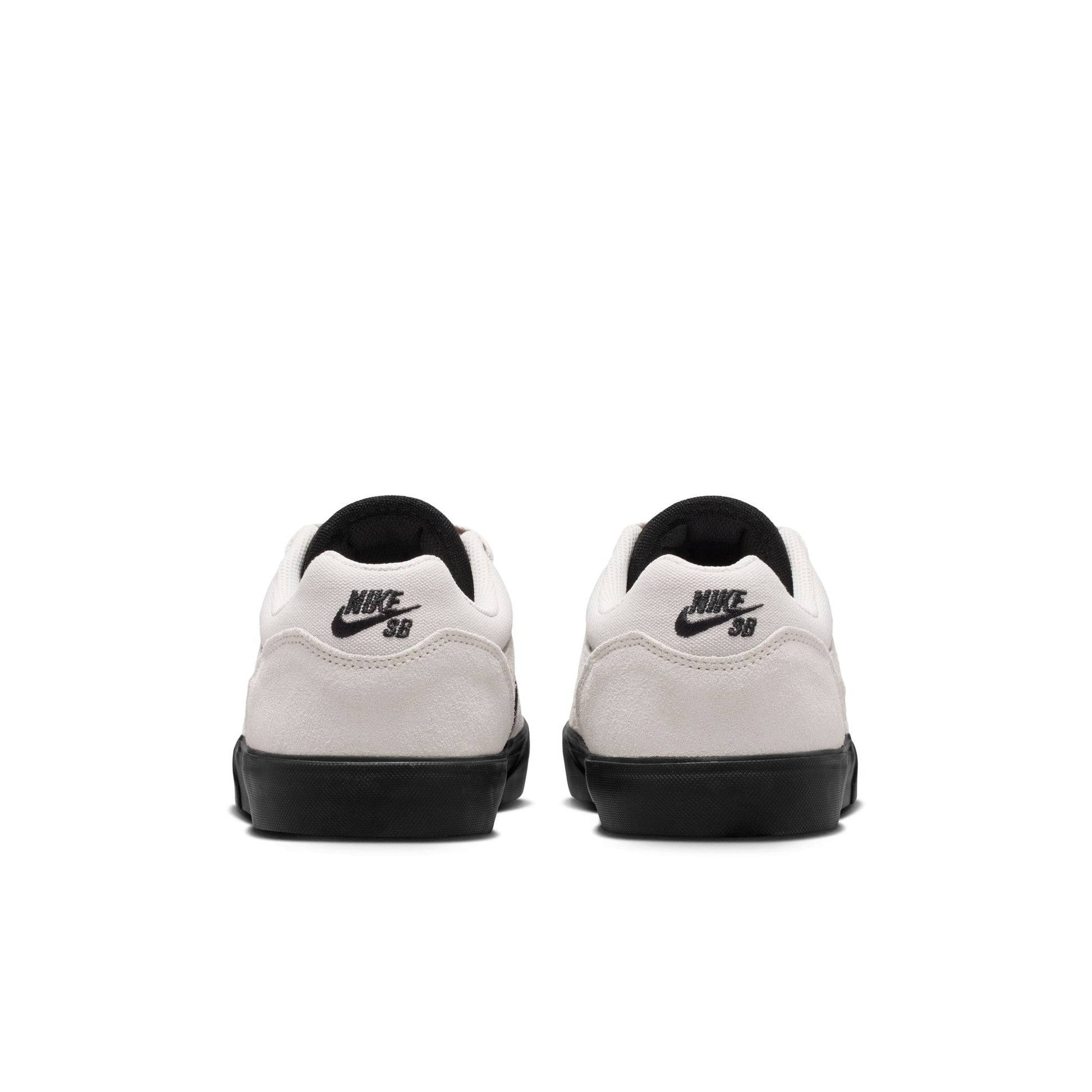 White sneakers with black soles and Nike SB logo on a white background