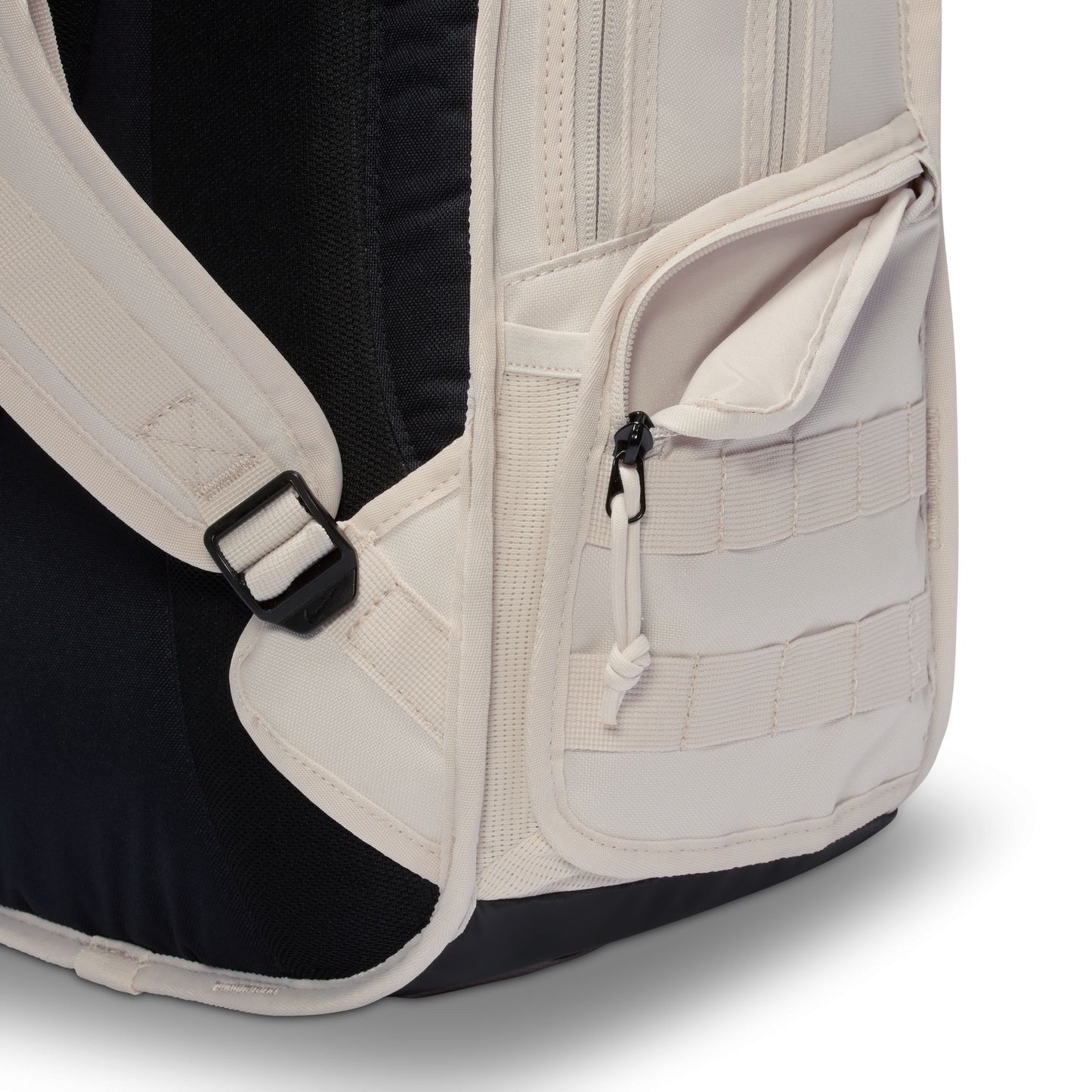Close-up of a backpack with beige straps and black interior on a white background