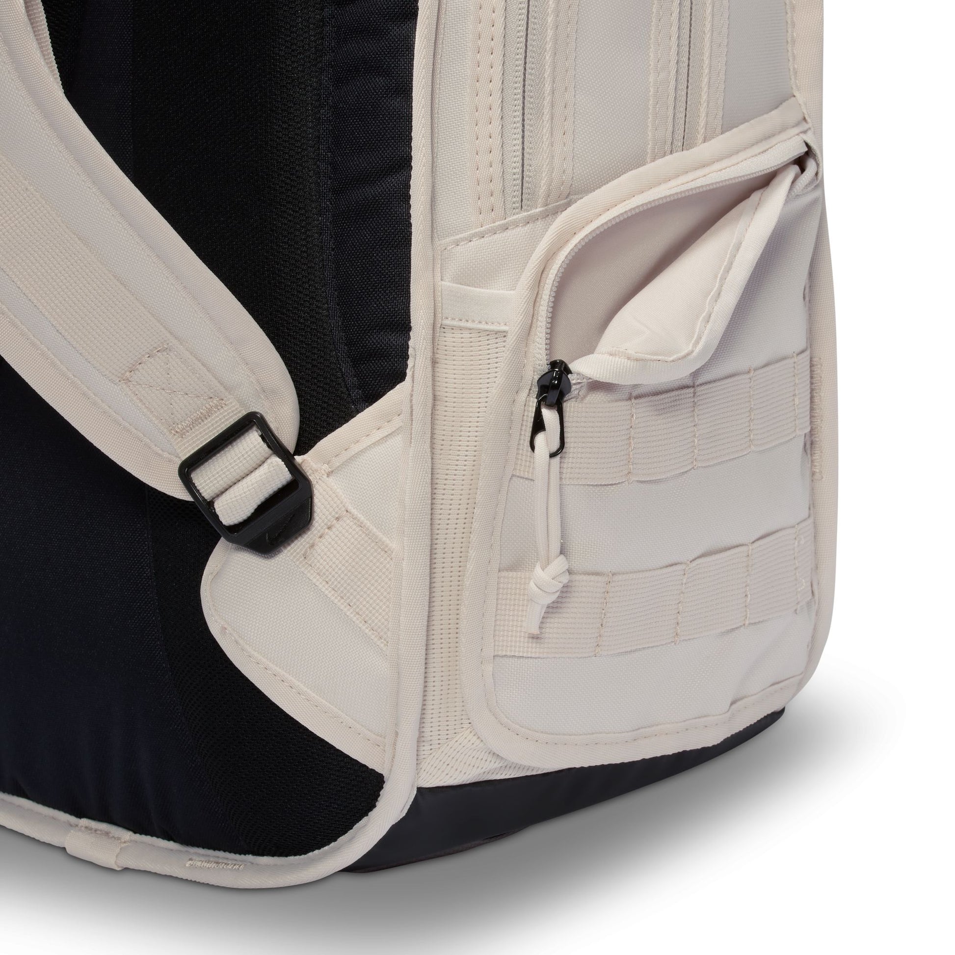 Close-up of a backpack with beige straps and black interior on a white background