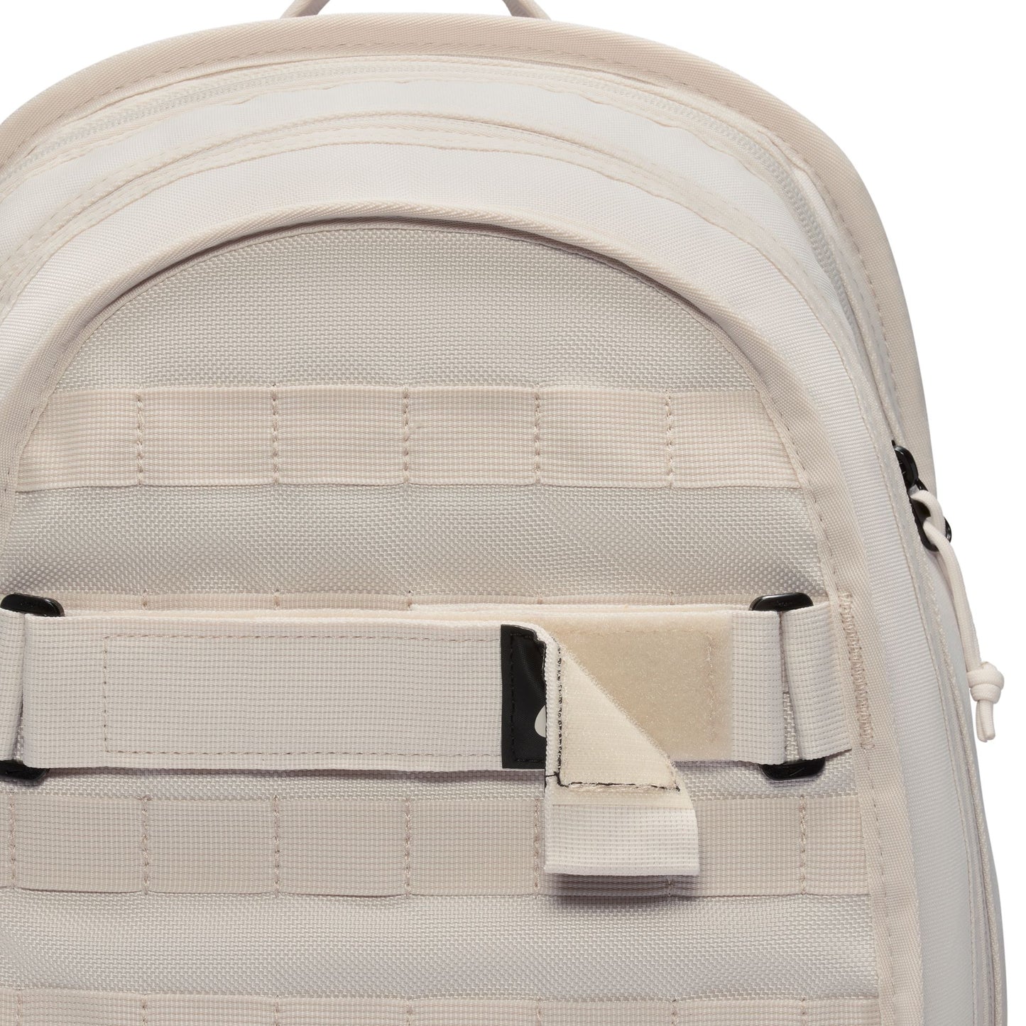 Close-up of a beige backpack with straps and zippers on a white background