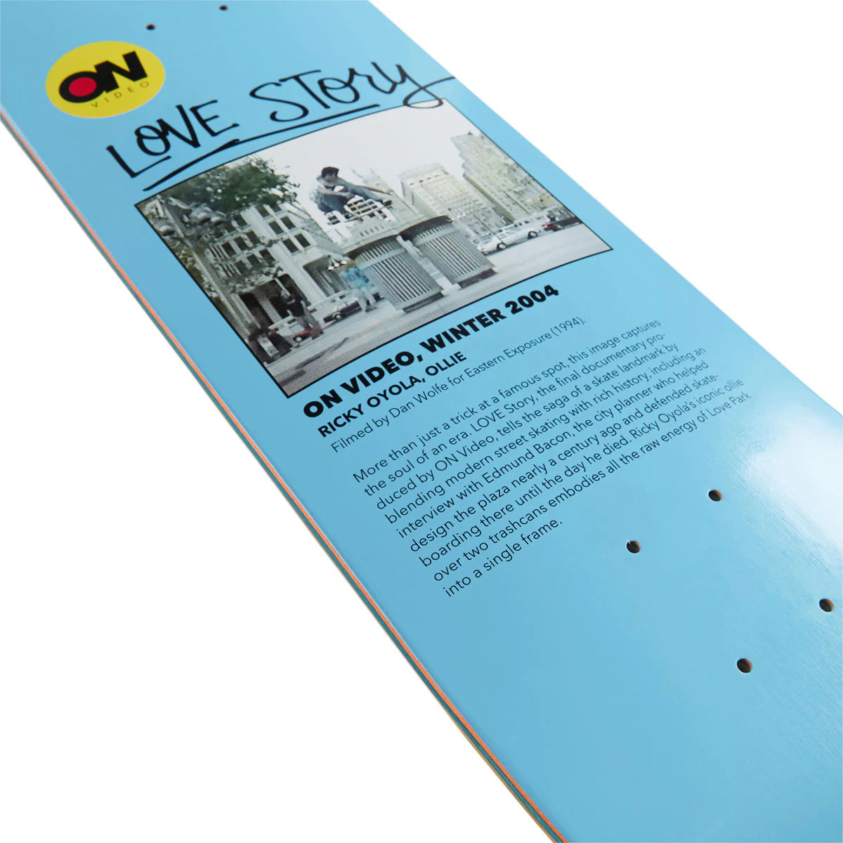 Skateboard deck with 'Love Story' text and a photo of a city street, featuring the ON Board logo.