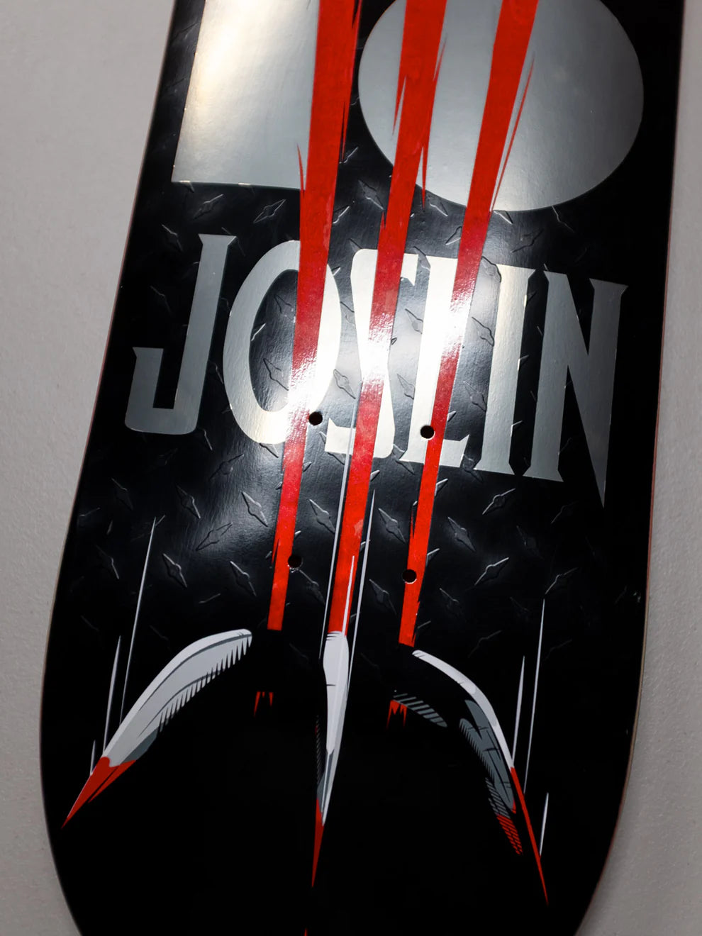 Black and red skateboard deck with 'JOSLIN' branding on a gray background
