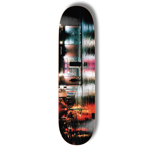 Skateboard deck with a colorful cityscape design on a white background