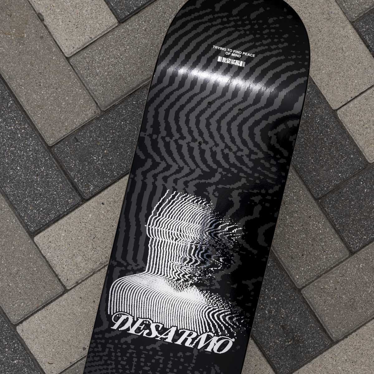 Black and white skateboard deck with 'Desarmo' branding on a textured surface