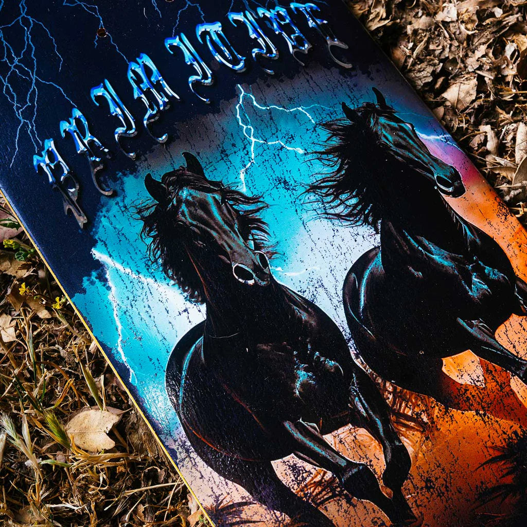 Skateboard with horse design on a grassy surface