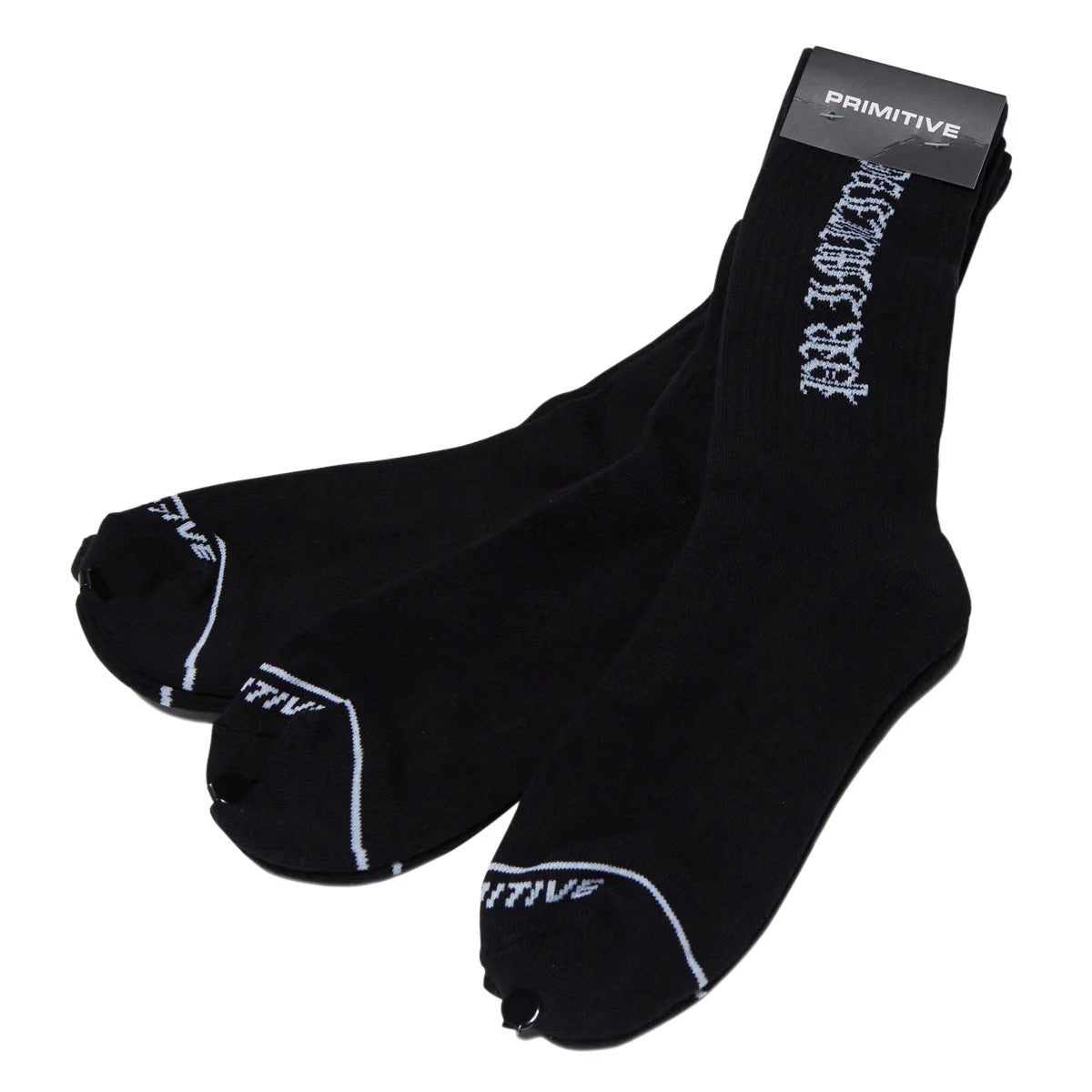 A pair of black crew socks with white graphic text and stripe details, featuring a black cardboard insert at the top with the brand name 'PRIMITIVE'.