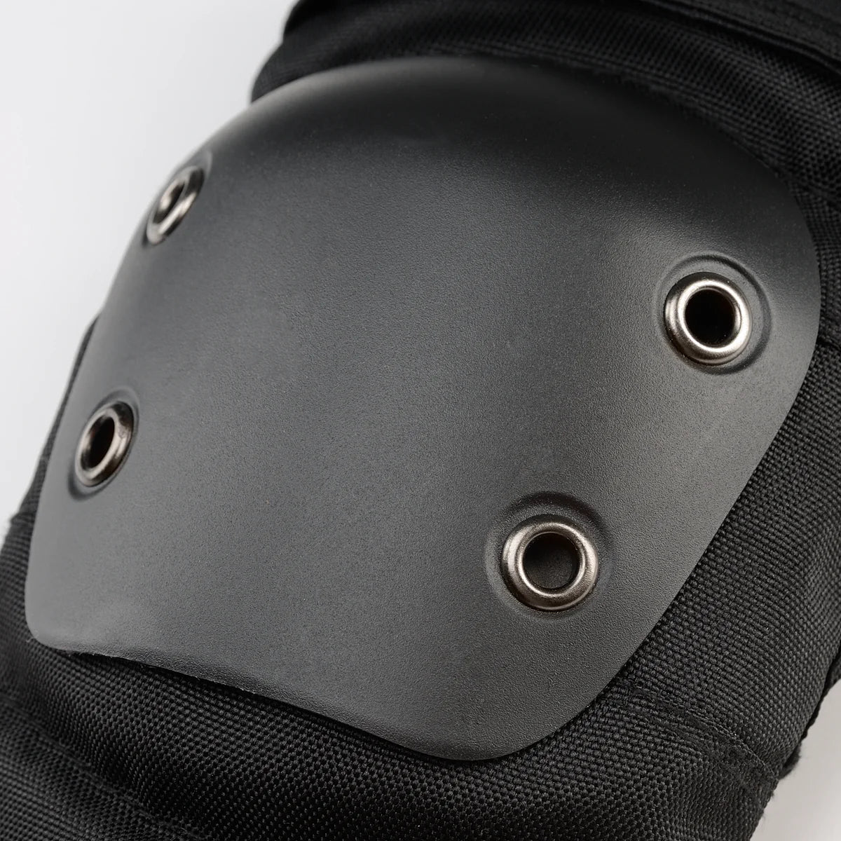 Black elbow pad with metal eyelets on a plain background