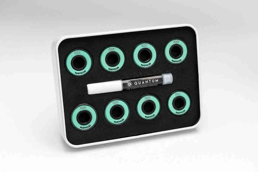 Set of Quantum brand items including a black tray with green circular components and a white pen on a light gray background.