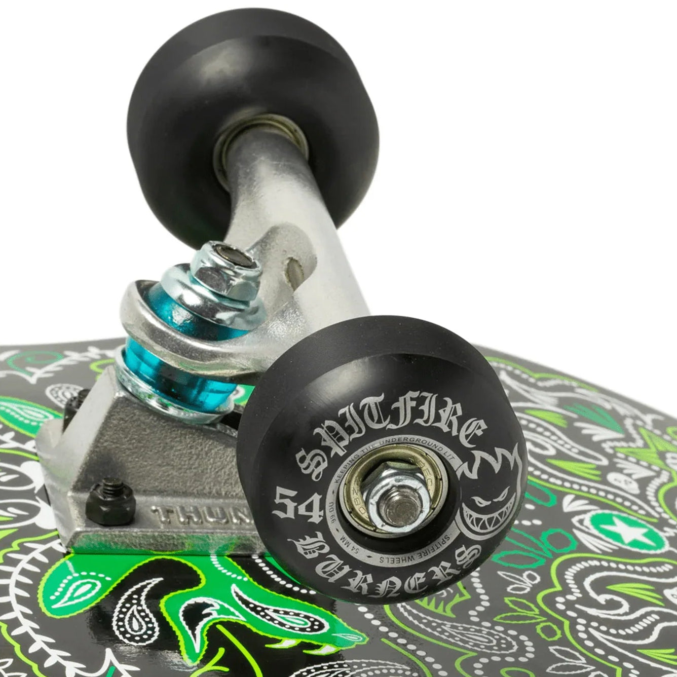 Close-up of a skateboard with a patterned deck and visible trucks on a white background