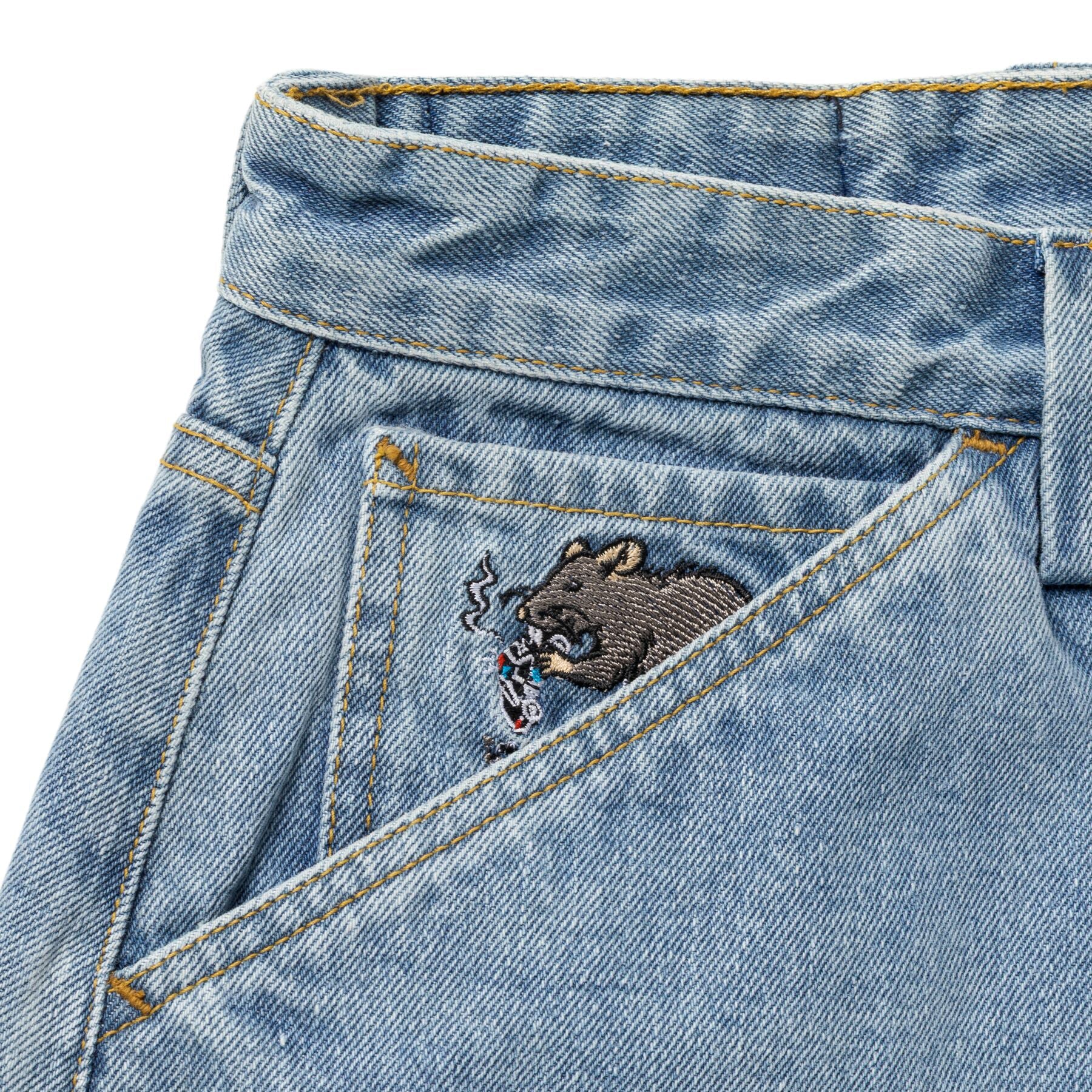 Close-up of a denim pocket with a bear embroidered design on a white background