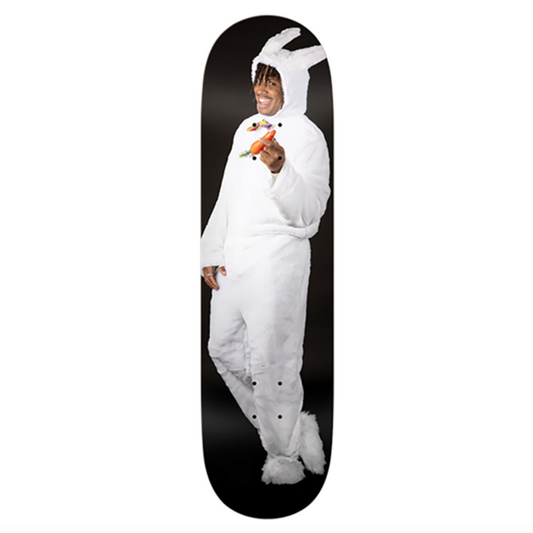 Person in a white bunny onesie standing on a skateboard deck with a white background