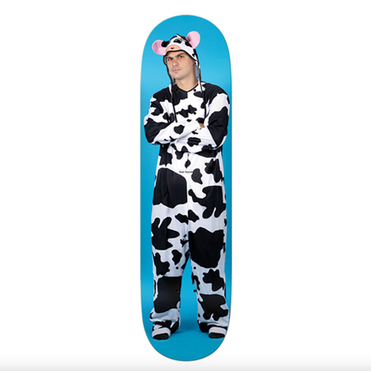 Person wearing a cow onesie standing on a blue skateboard deck.