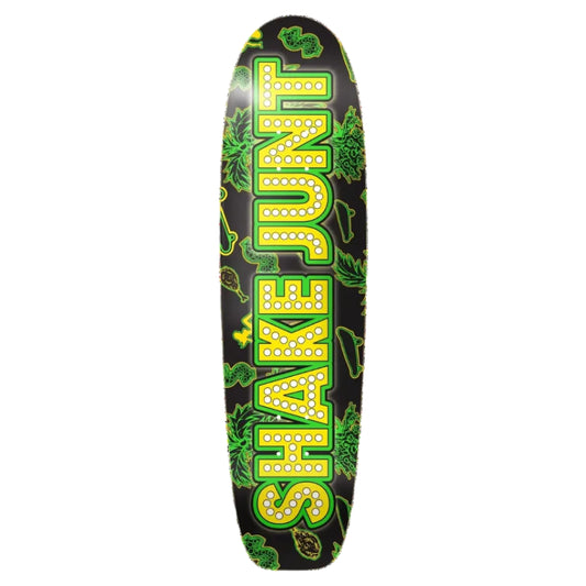A skateboard deck featuring a black background with a large vertical 'SHAKE JUNT' logo in yellow letters outlined in green, decorated with green cannabis leaf illustrations.