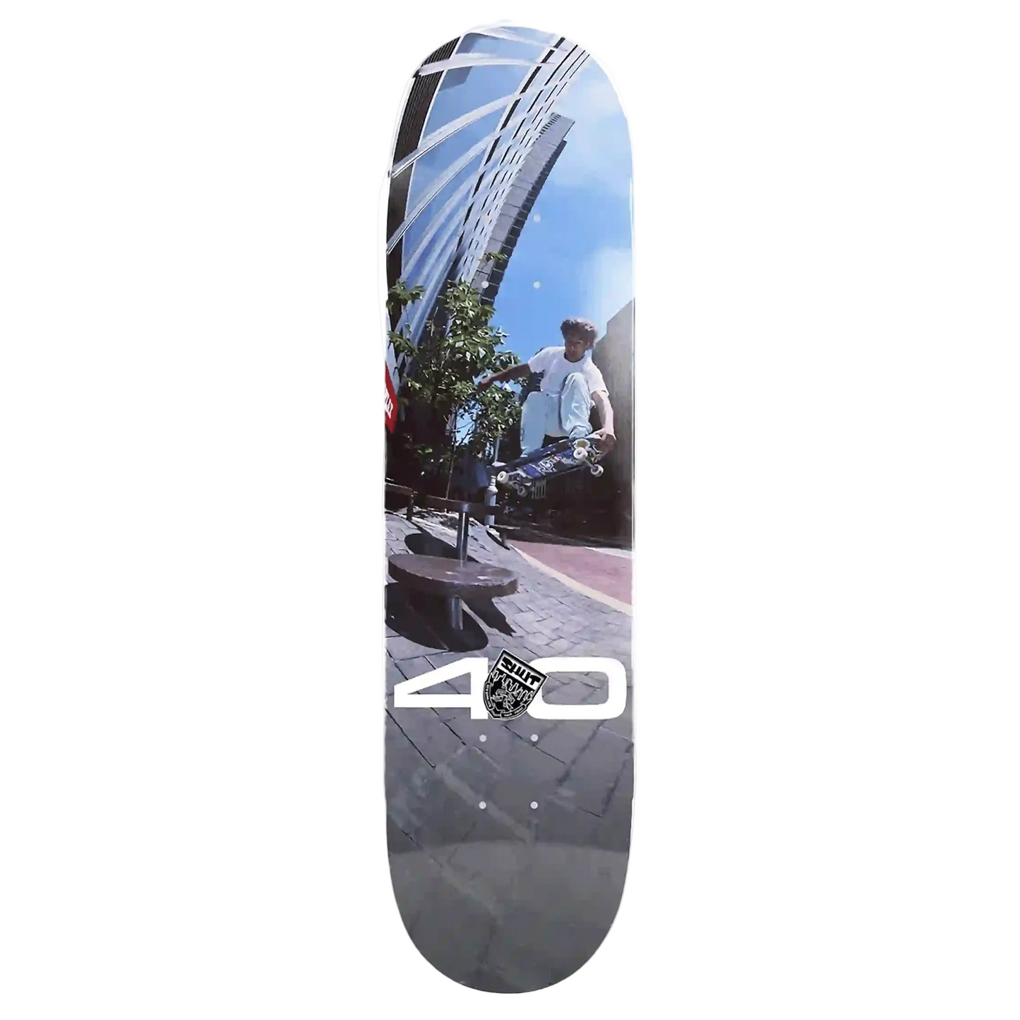 A skateboard deck featuring a photographic print of a street scene with a person on a scooter, a modern building, and a blue sky, with a large white '40' logo and a circular 'Street' shield logo near the bottom.