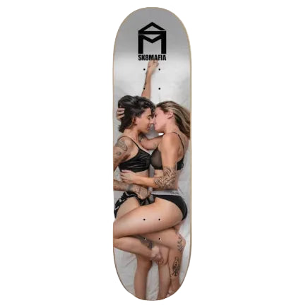 A skateboard deck featuring a printed graphic of two women embracing and kissing, with a black 'SKBMAFIA' logo at the top, shown against a plain white background.