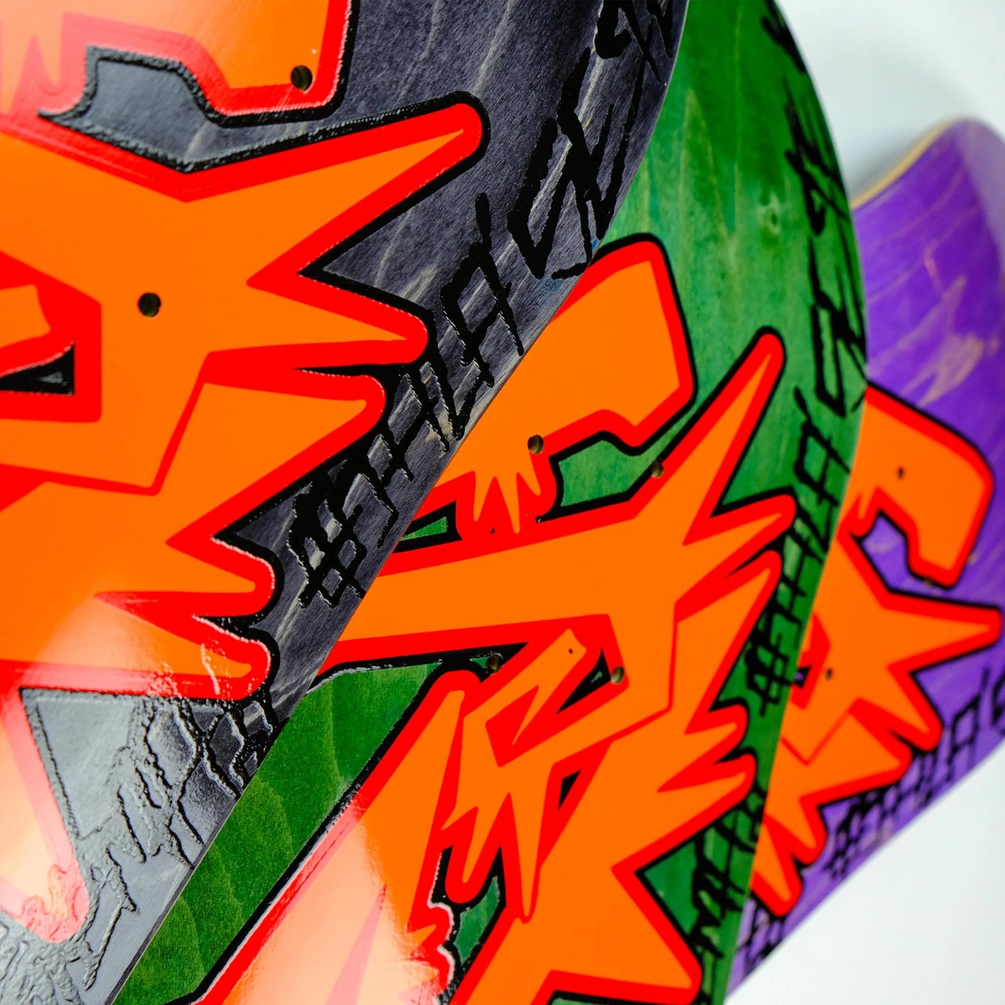 Close-up of colorful skateboard decks with vibrant graphics and text.