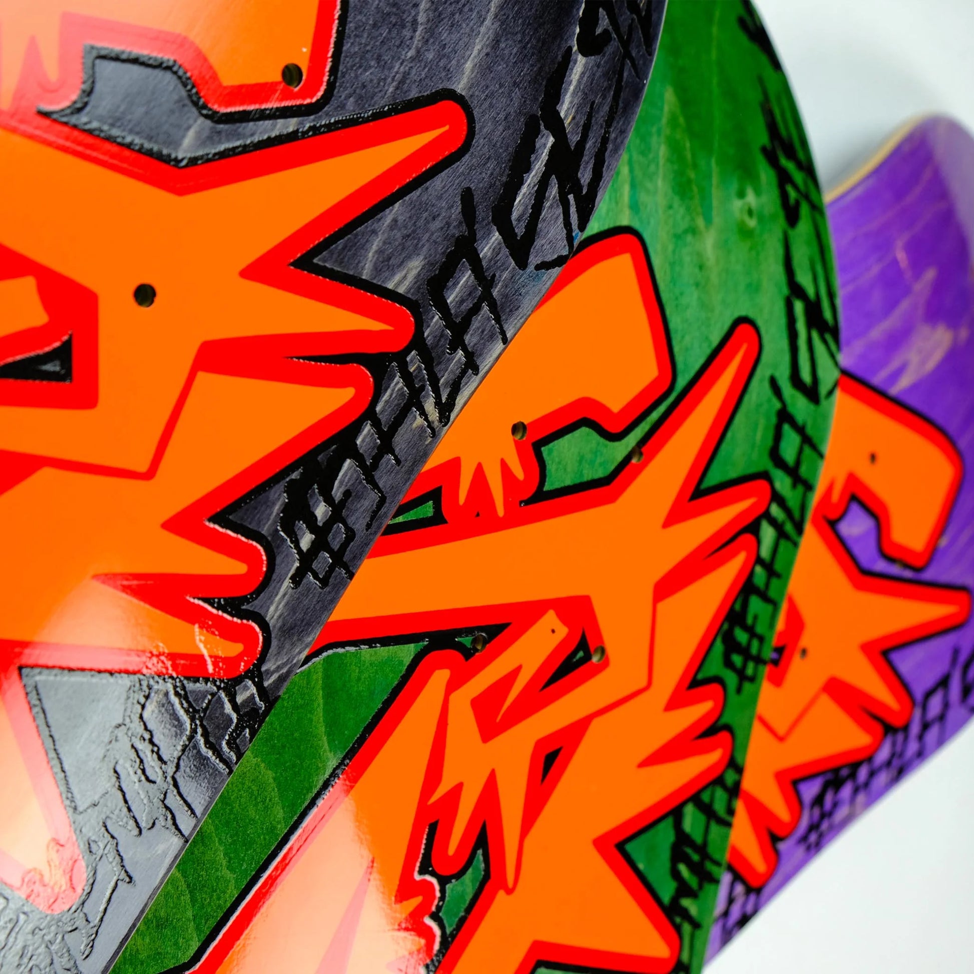 Close-up of colorful skateboard decks with vibrant graphics and text.