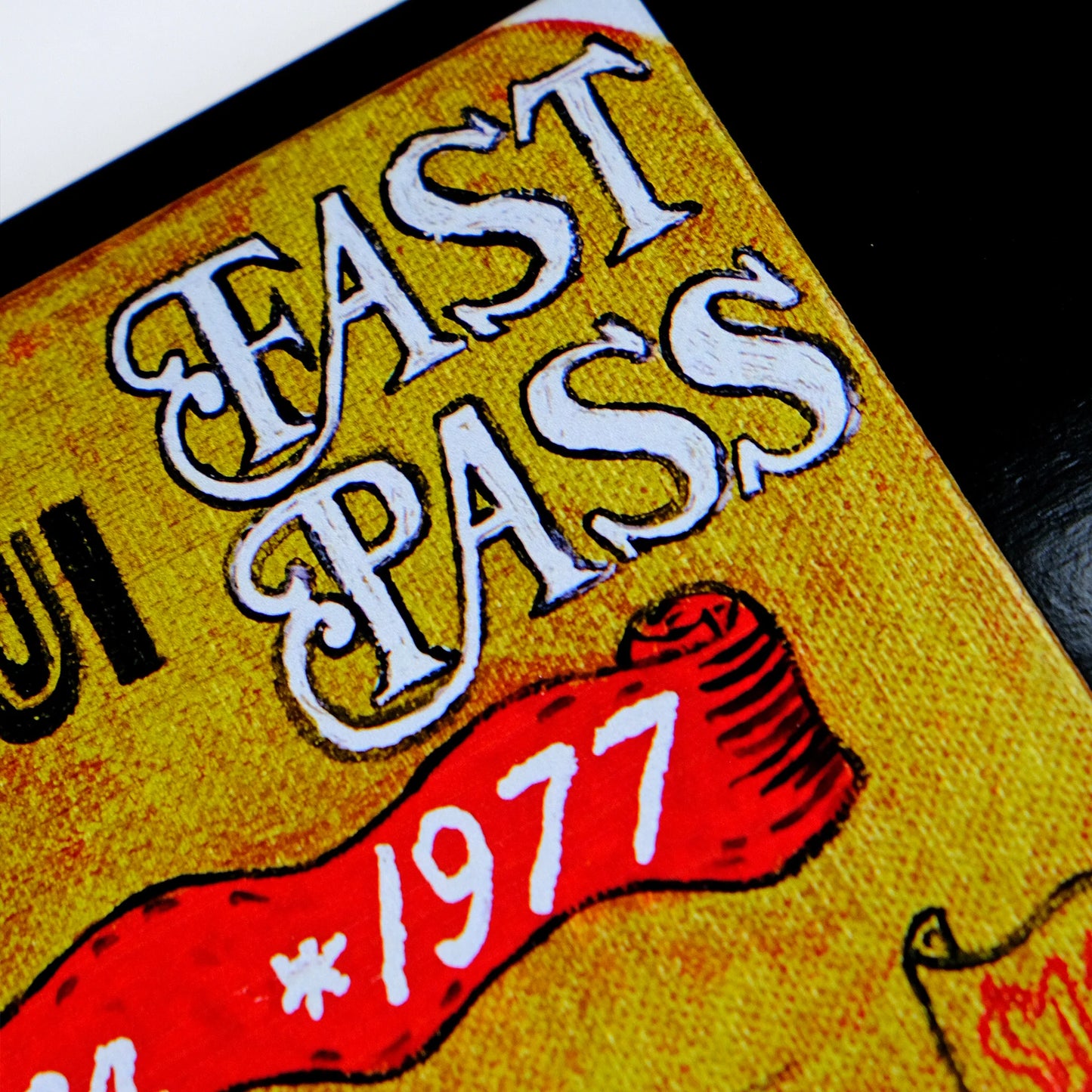 Vintage-style 'Fast Pass' ticket with red ribbon and '1977' text on a yellow background.