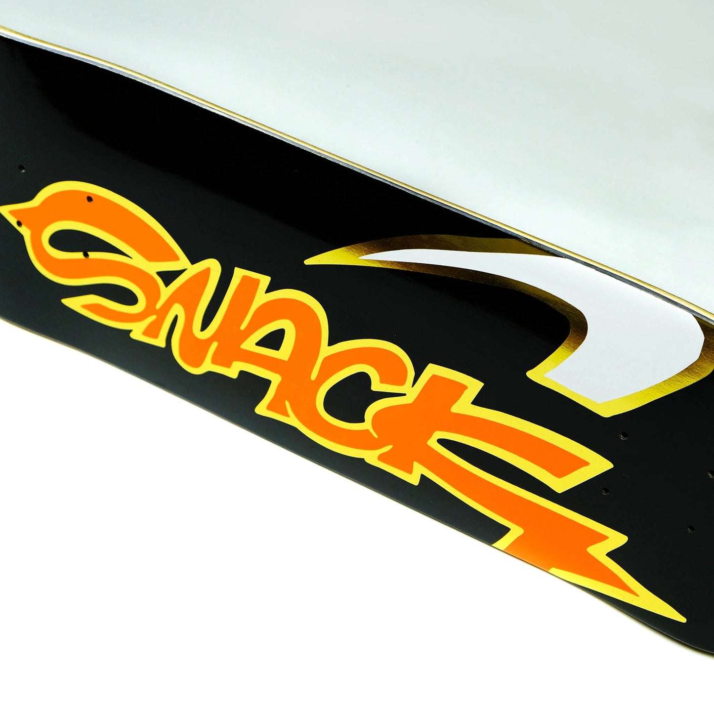 Close-up of a skateboard with 'Snack' logo on a black background