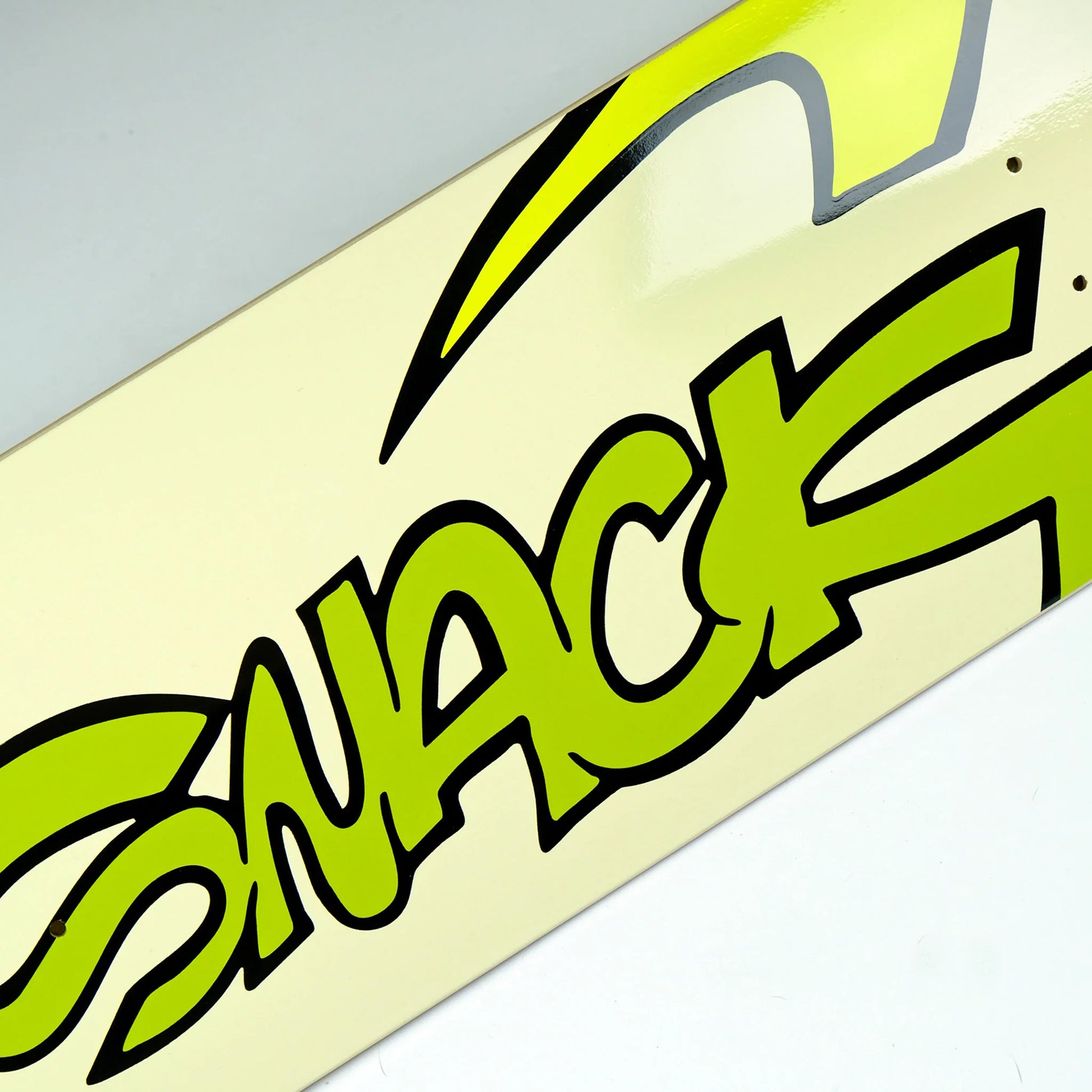 Close-up of a skateboard with a green 'Snack' logo on a light background