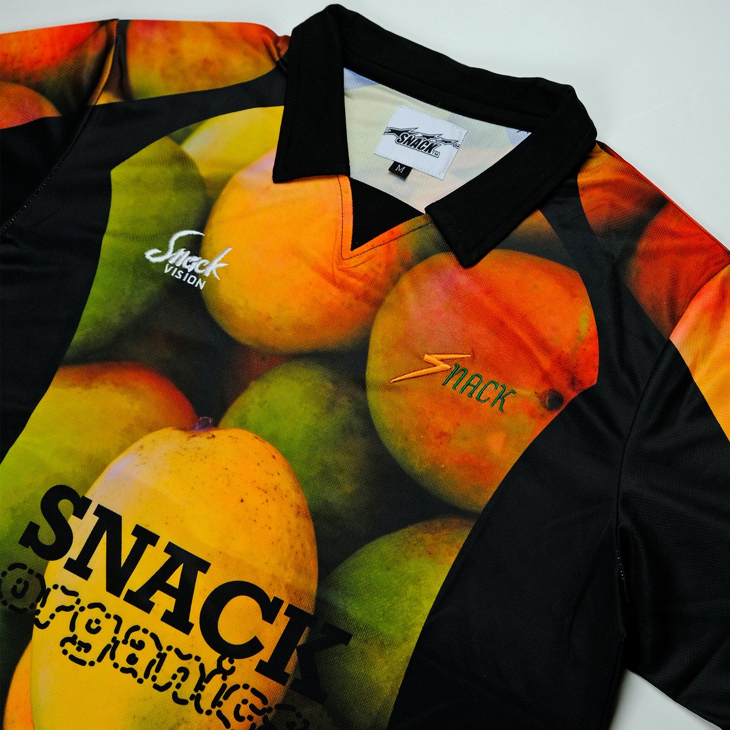 Shirt with fruit design and 'Snack' branding on a white background