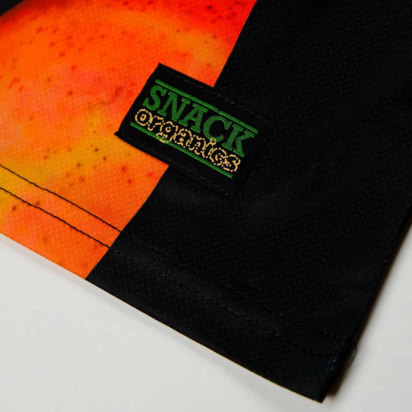 Black fabric with 'Snack' logo on a colorful background