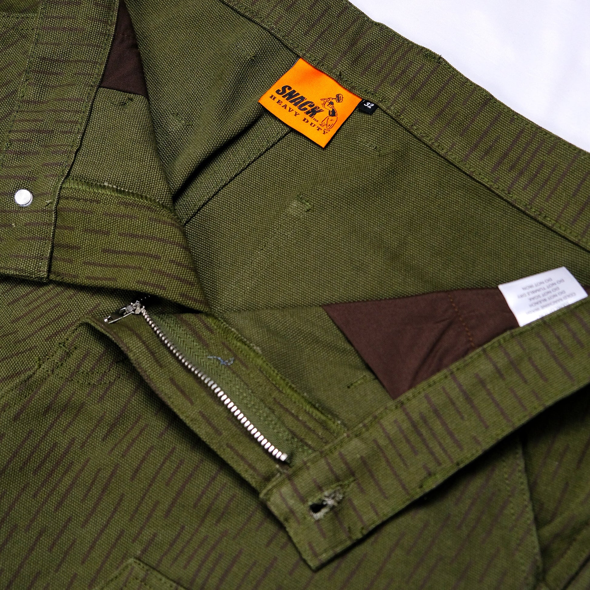 Close-up of a green jacket with a brand label on a white background