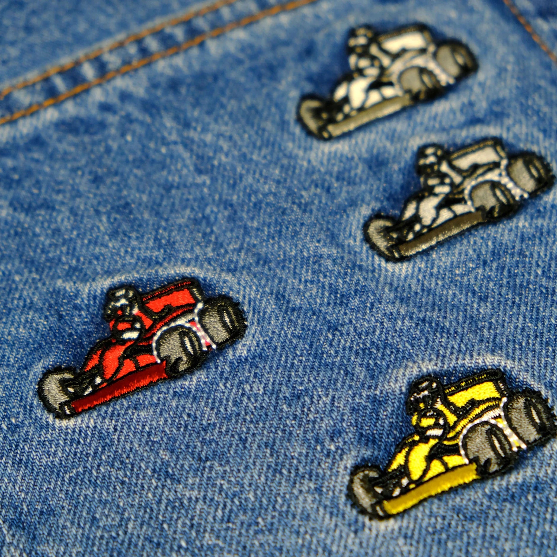 Embroidered patches of racing cars on a denim fabric background