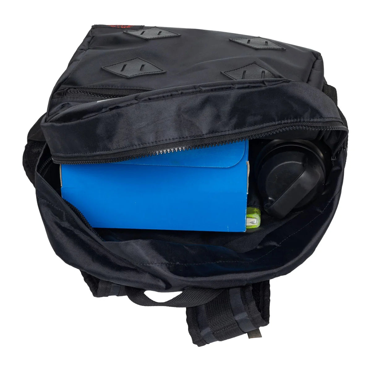 A black backpack shown open from above, revealing its interior compartments. Inside, a bright blue envelope-style pouch is tucked next to a black circular item, with a small green object visible at the edge.