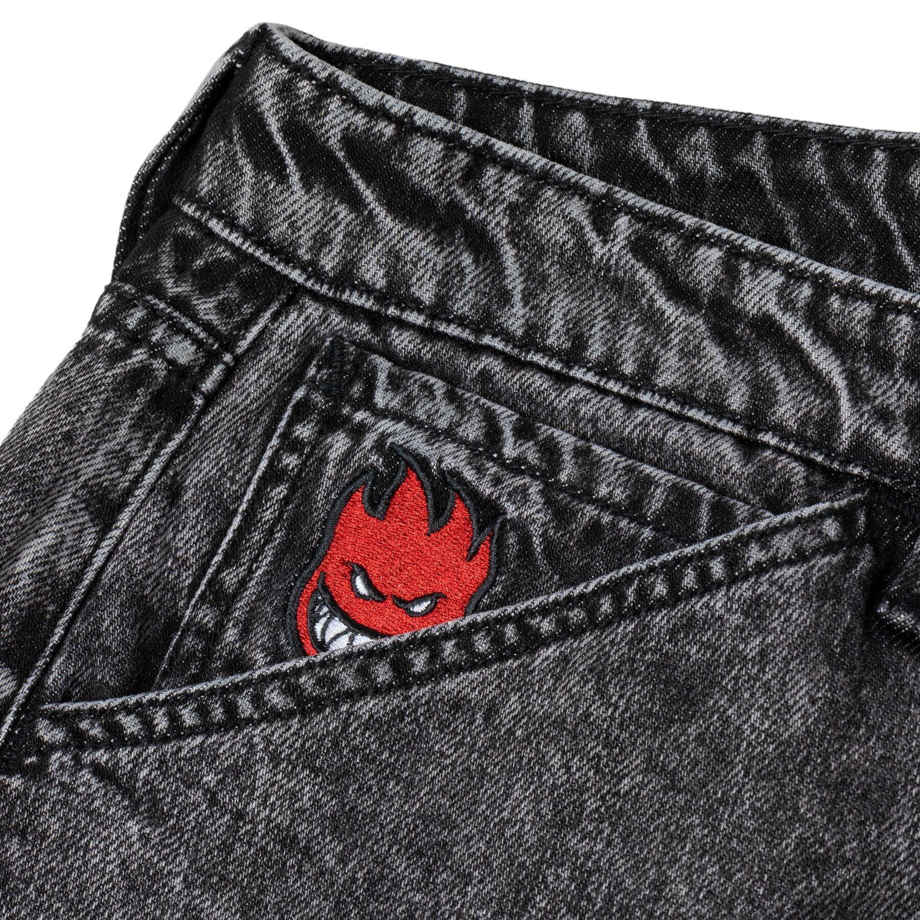 Close-up of a black denim pocket with a red and black embroidered logo on a white background