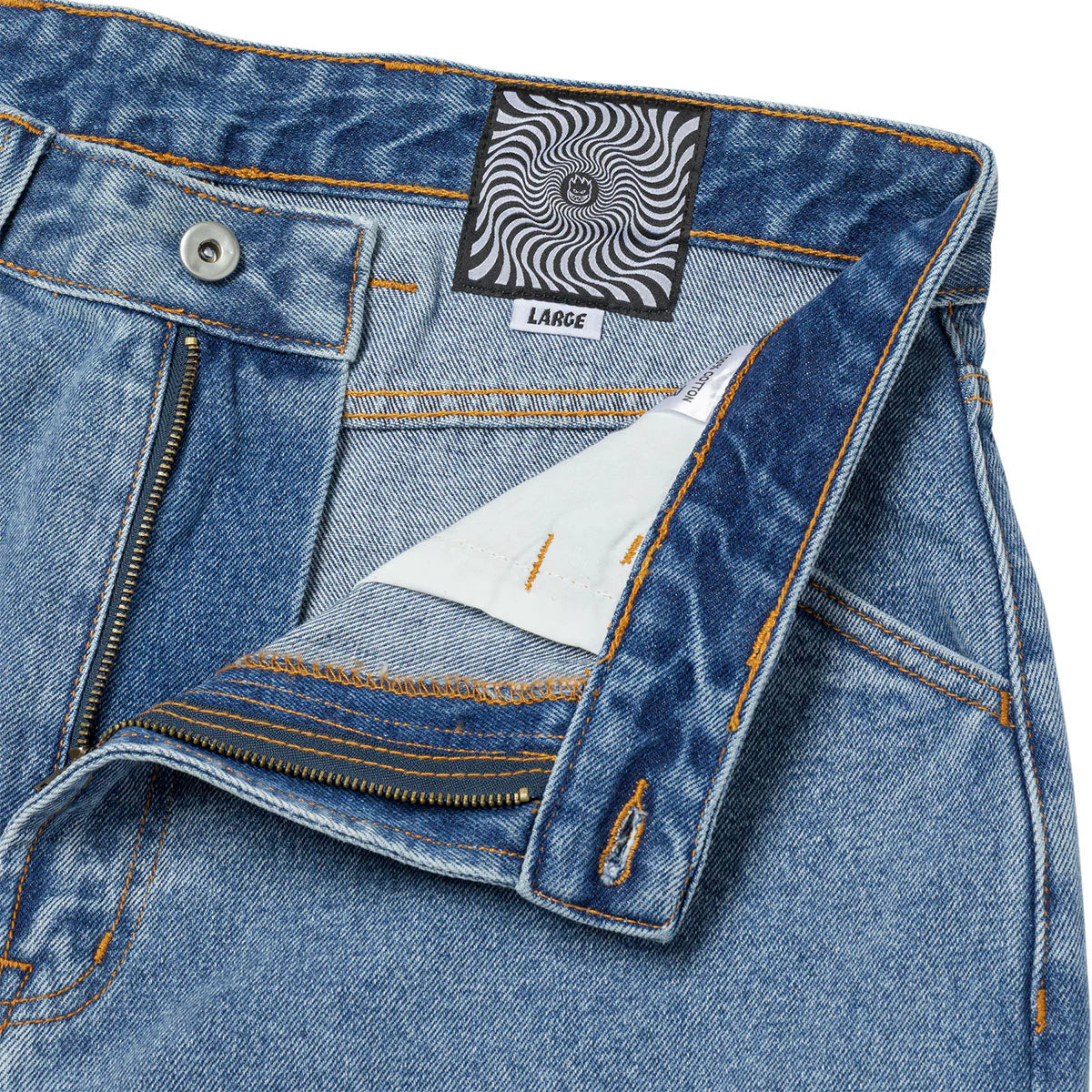 Close-up of blue denim jeans with a brand label on a white background