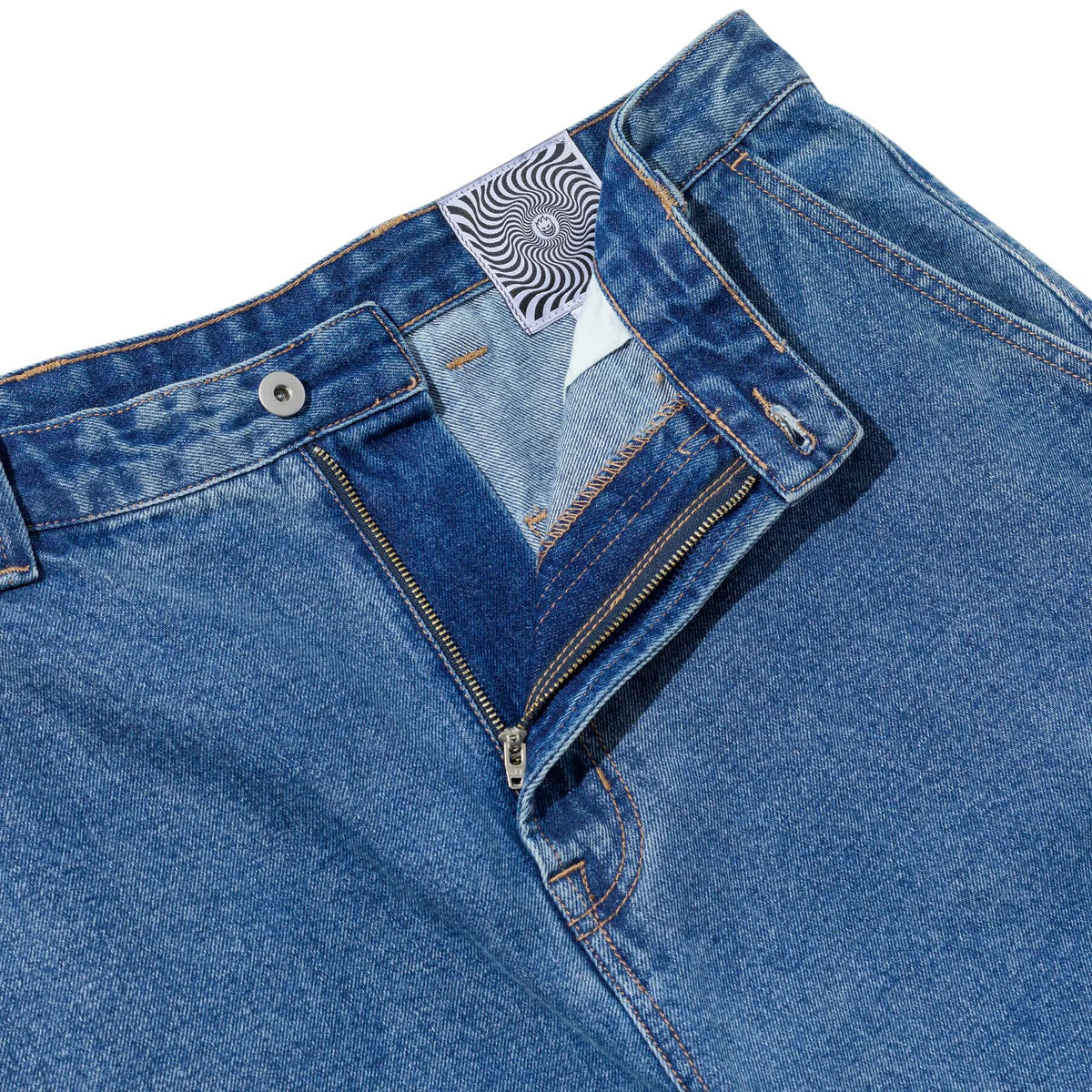Close-up of blue jeans with a brand label on a white background