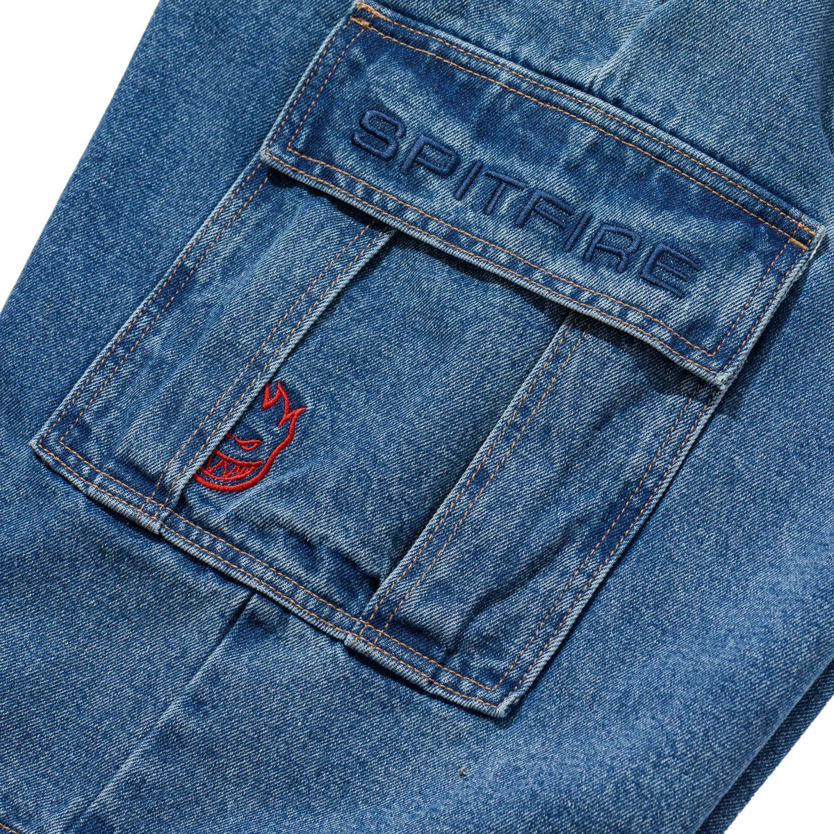 Close-up of a blue denim pocket with 'Spitfire' branding.