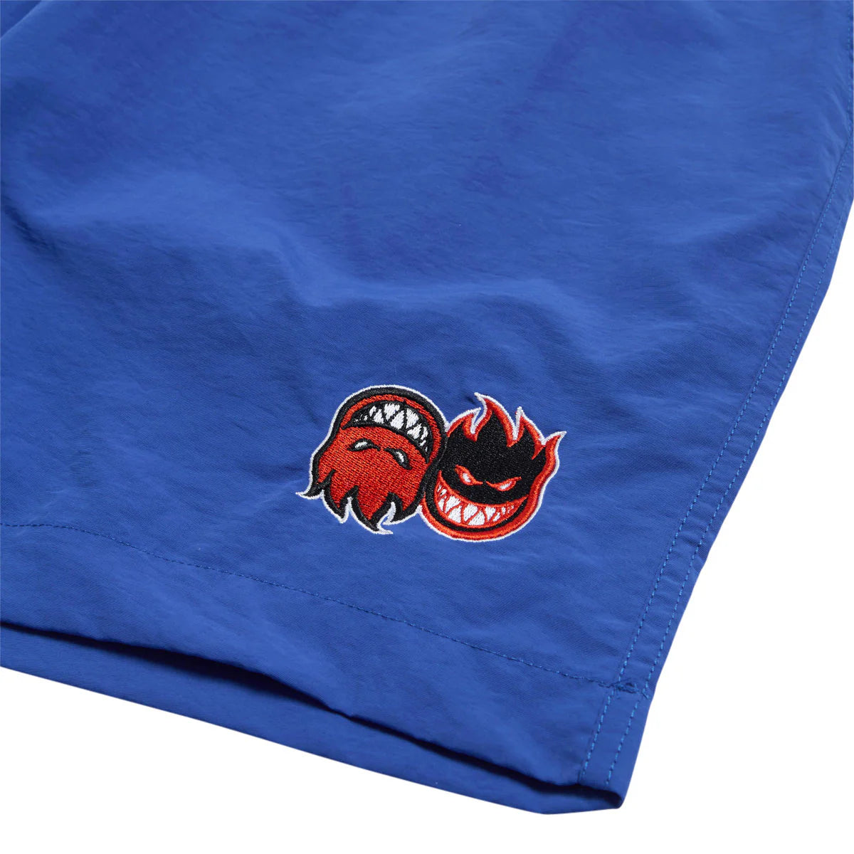 Blue fabric with a red and black embroidered design on a white background