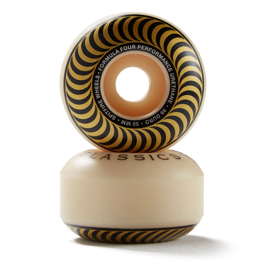 A pair of classic skateboard wheels stacked vertically on a white background. The top wheel shows a black and yellow spiral pattern with white text detailing the specifications, while the bottom wheel is a solid cream color with 'CLASSICS' printed on it.