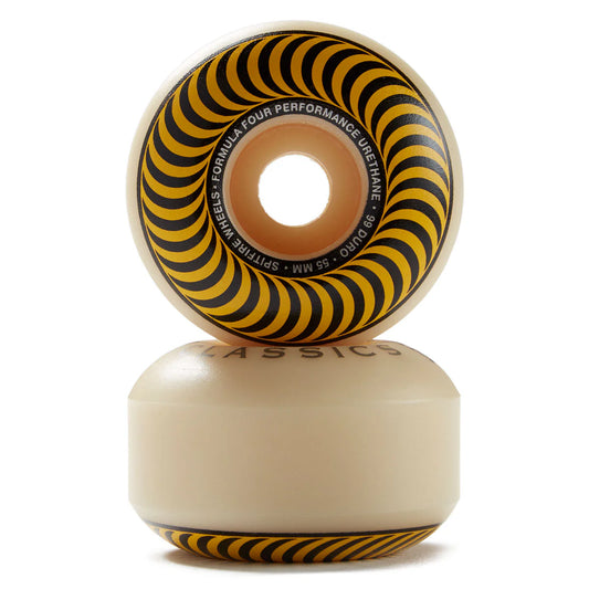 A pair of Spitzer Wheels skateboard wheels stacked vertically on a white background. The wheels have a translucent cream-colored urethane body with a bold black and yellow spiral pattern on the inner barrel.