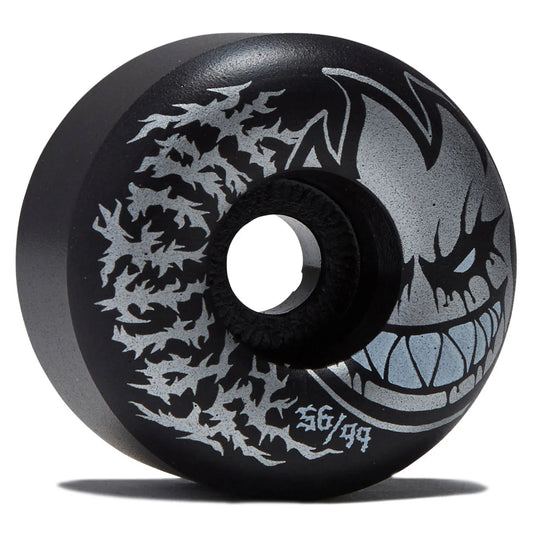 A black skateboard wheel with a silver graphic of a monster's face and sharp teeth, alongside a silver splatter design and the text '56/99'.