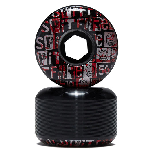 A pair of skateboard wheels stacked vertically on a white background. The top wheel is upright, showing a black base with a red and white graphic pattern of the word 'SPIRIT' and flames.