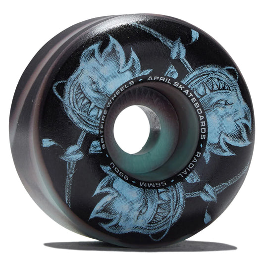 A single skateboard wheel with a black outer barrel and a translucent teal-green center, featuring a light blue graphic of a demonic face with sharp teeth. White text on the wheel reads 'SPITFire Wheels', 'April Skateboards', and 'radial'.
