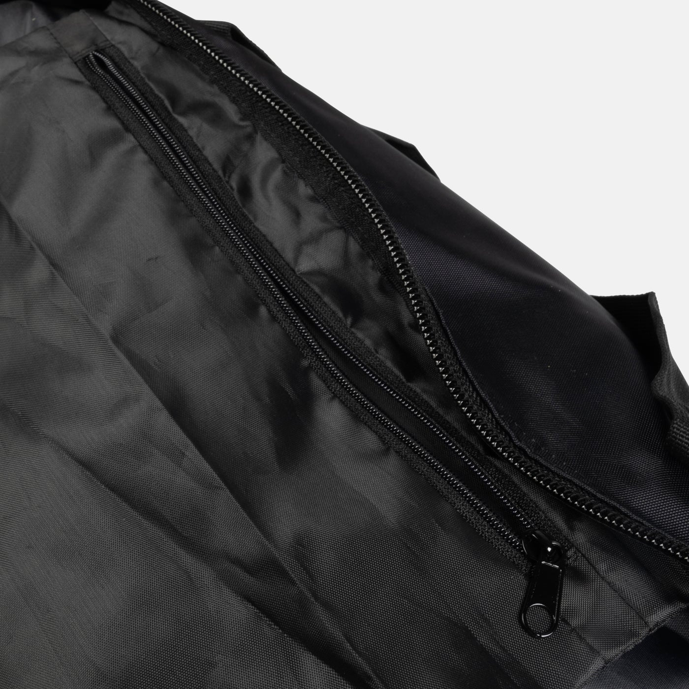 Close-up of a black duffel bag with a zipper on a light gray background
