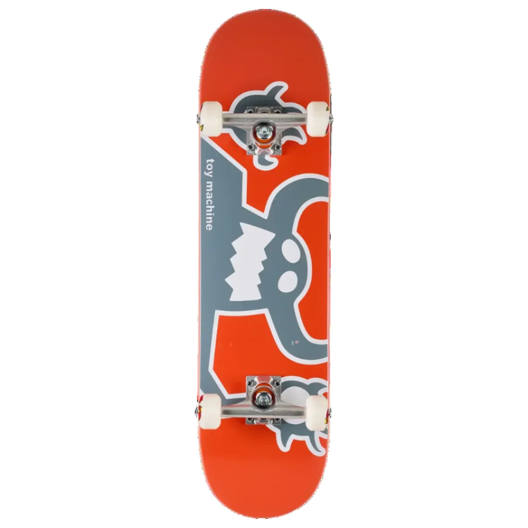 A toy skateboard shown from a top-down view on a solid white background. The deck is bright orange with a large gray cartoon monster graphic and the text 'toy machine' printed vertically.