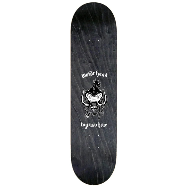 A skateboard deck featuring a dark wood-grain black background with a white graphic of a horned skull and the text 'motorhead toy machine' printed in the center.