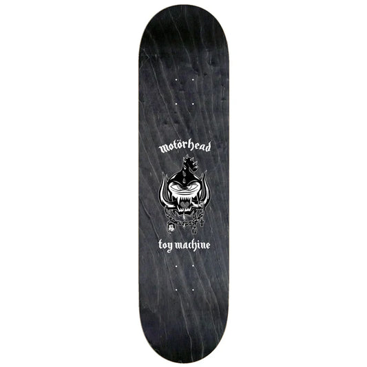 A skateboard deck featuring a dark wood-grain black background with a white graphic of a horned skull and the text 'motorhead toy machine' printed in the center.