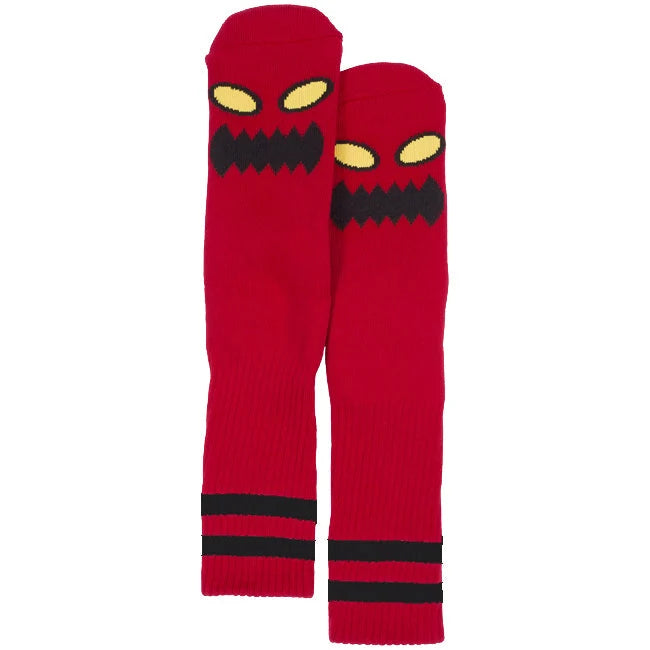 Red socks with a cartoonish face design on a white background