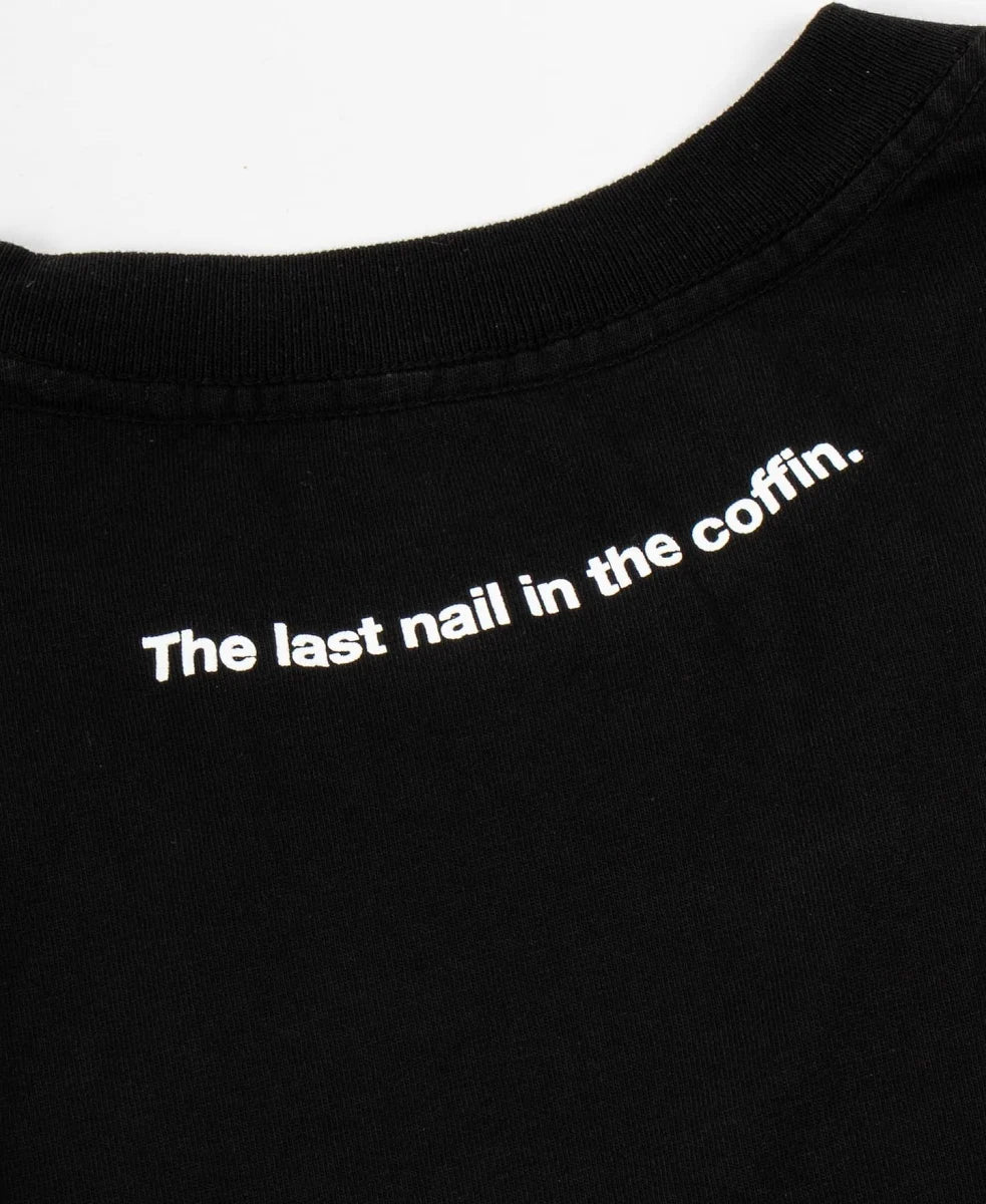 Close-up of a black crewneck t-shirt with the phrase 'The last nail in the coffin.' printed in white sans-serif text across the chest.