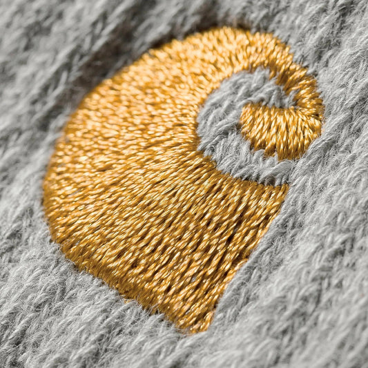 Gold embroidered design on a gray fabric background