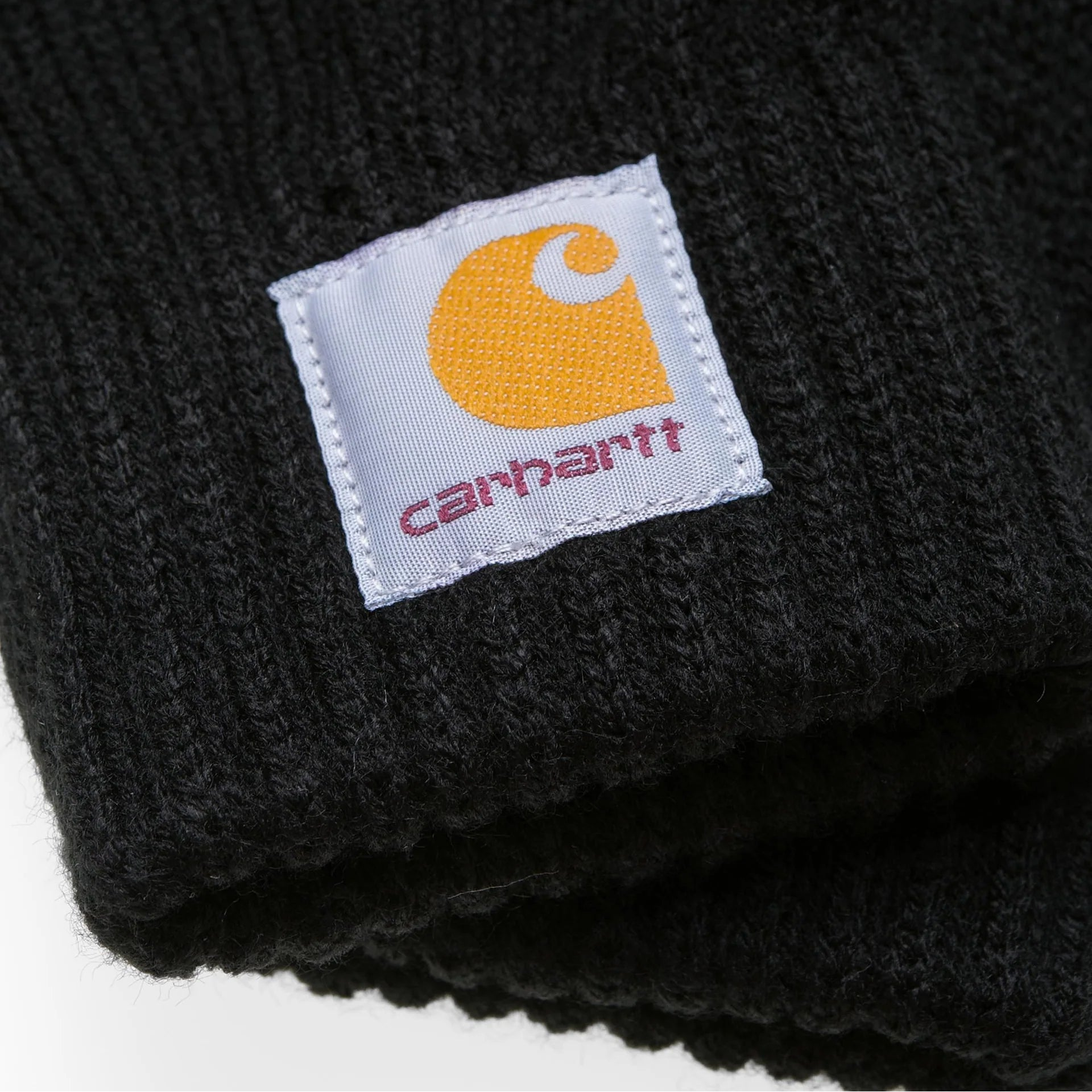 Black knit beanie with Carhartt logo tag on a white background